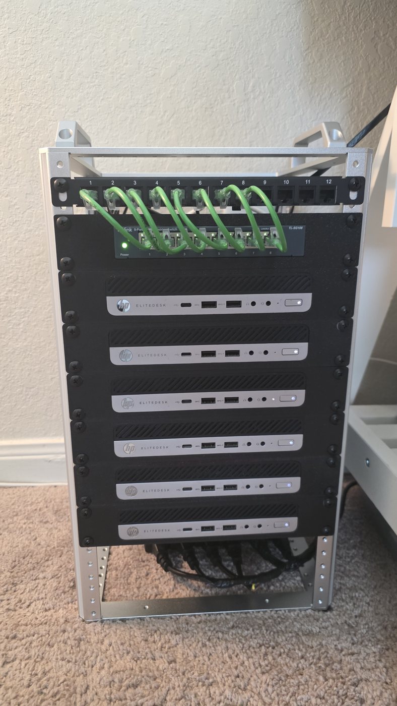 A 10-inch open-frame rack holding, top to bottom, a 12-port patch panel, an 8-port TP-Link switch, and six HP EliteDesk 800 G3 Mini nodes each in its own 1U tray.